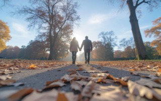 Paar spaziert Hand in Hand im Herbstpark – Hoffnung und Balance bei Kinderwunsch