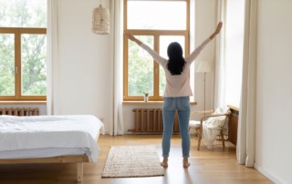 Frau steht aufrecht im warmen Licht und stärkt mit TCM Energie und Zuversicht vor der IVF